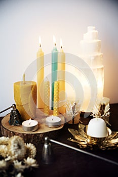 Still life with several natural beeswax candles, selenite lamp and two candle snuffers photo