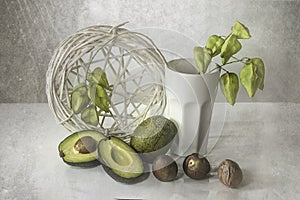 Still life with sliced avocado on white background