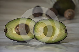 Still life with sliced avocado on white background