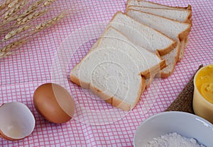 Still life with sliced bread,egg,flour,magarine and wheat on tab