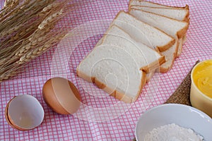 Still life with sliced bread,egg,flour,magarine and wheat on tab