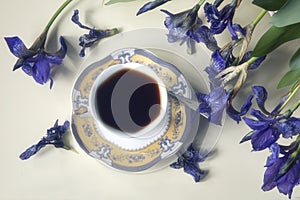 Still life with splendid bouquet wild irises  and coffee cup