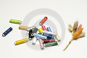 still life with spools of thread of various colors lying on a light blue