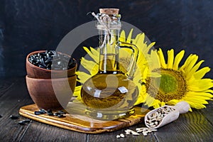 Still life with sunflower oil in glass bottle, seed and sunflower