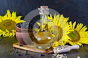 Still life with sunflower oil in glass bottle, seed and sunflower