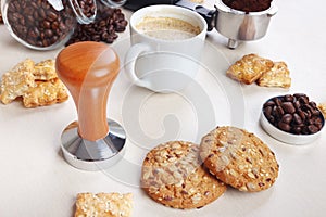 Still life with sweets, cup of coffee, coffee beans and ground coffee on table