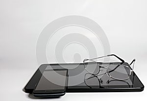 Still Life of Tablet, Cell Phone and Reading Glasses