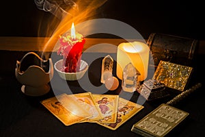 Still life with tarot cards, candles, incense and other objects on a black card table