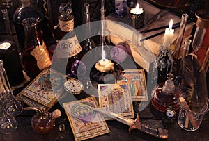 Still life with the tarot cards, knife, books and candles on witch table