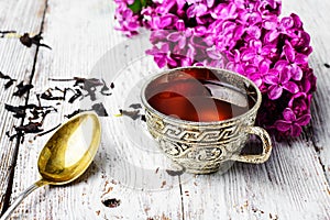 Still life with tea and branch of lilac