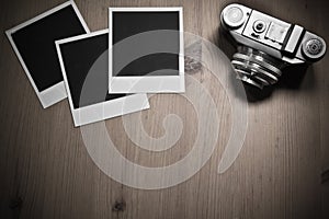 Still life three blank instant photo frames on old wooden background with old retro vintage camera with copy space