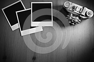 Still life three blank instant photo frames on old wooden background with old retro vintage camera with copy space