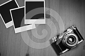 Still life three blank instant photo frames on old wooden background with old retro vintage camera with copy space