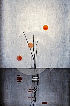 Still life with three orange balls, a glass and chopsticks