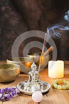 Still life with Tibetan singing bowls, minerals, a candle, incense and a Buddha figure