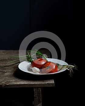 Still life with tomatoes and scallions on old wooden table