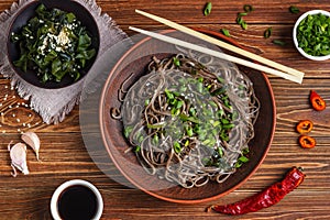 Still life with top view of traditional japanese soba noodles with nori edible seaweed and soy sauce