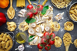 Still life of tortellini, tagliatelle, tortiglioni, fusilloni, casarecce, spaghhetti, macoroni, tomato, mushroom, pepper, olive