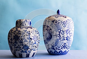 Still life with two blue and white ceramic ginger jars isolated on blue