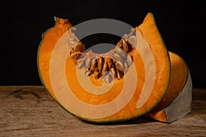 Still life with two slices of pumpkin on a dark background in a minimalist style
