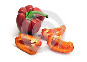 Two whole and cutted red ripe bell peppers isolated on white background close up