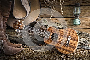 Still life with ukulele on cowboy hat and traditional leather bo