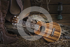 Still life with ukulele on cowboy hat and traditional leather bo