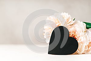 Still life Valentines day festive background with empty black chalkboard heart on white table background. Mockup with