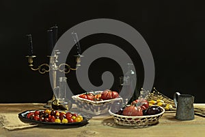 Still life with various types of delicious ripe tomatoes, cherry tomatoes, glass oil can