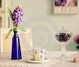 Still life with vase hyacinth flowers tea cup rose
