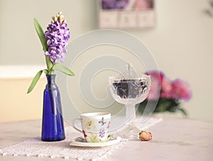 Still life with vase hyacinth flowers tea cup rose and blue wal