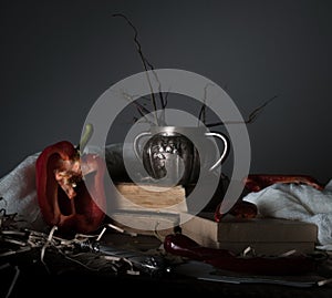 Still life, vintage. old silver vase, red pepper, mill, and a towel on wooden table.