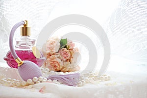 Still life with Vintage perfume bottle and dried pink roses in boudoir room.