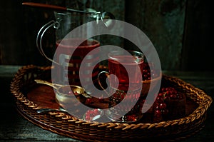 Still life in vintage style. Glass and decanter with red current tea or fruit-drink