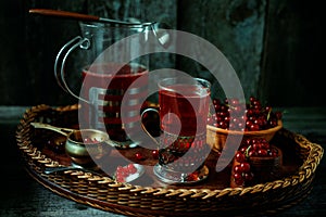 Still life in vintage style. Glass and decanter with red current tea or fruit-drink