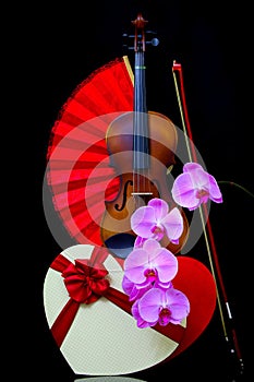 Retro violin with bow and phalaenopsis blume pink orchids on dark background photo