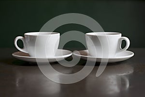 Still life, white kettle and cups on the table