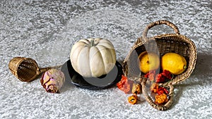 still life on a white tablecloth, fruit in a wicker basket and other objects