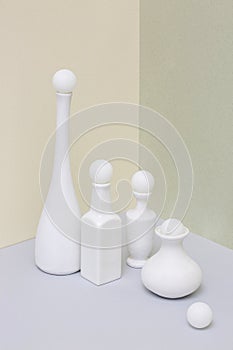 Still life with white vases and balls on a light background
