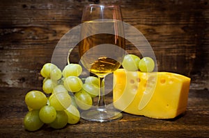 Still life with white wine , cheese and grapes