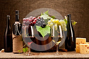 Still life with wine bottles, glasses and grapes