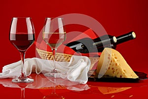 Still life with wine and cheese on a red background