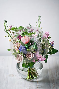 Still life. a wooden antique table, glass vase with Mixed bouquet. beautiful flowers