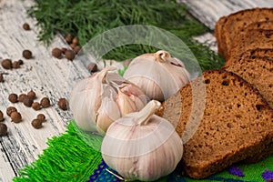 Still life on wooden background: bread, garlic, fennel, bayberry