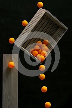 Still life with a wooden box and falling balls