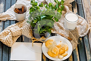 Still life on a wooden table with plate of cookies and glass milk