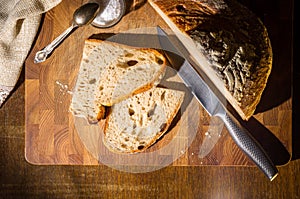 Still life - yeast-free buckwheat bread with sliced pieces, and coarse salt in a glass jar, a knife, and a linen napkin