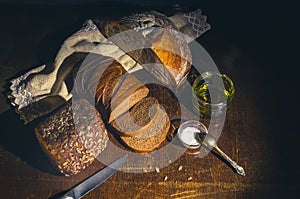 Still life - yeast-free buckwheat bread, various types of black bread, with olive oil and coarse salt in glass jars, a