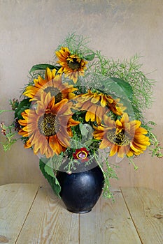 Bouquet with yellow and orange sunflowers in a clay vase on a white background