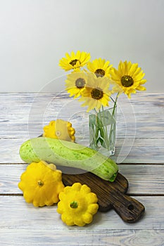 Still life of zucchini and flowers. Contrast of colors between yellow and green. Harvest healthy foods